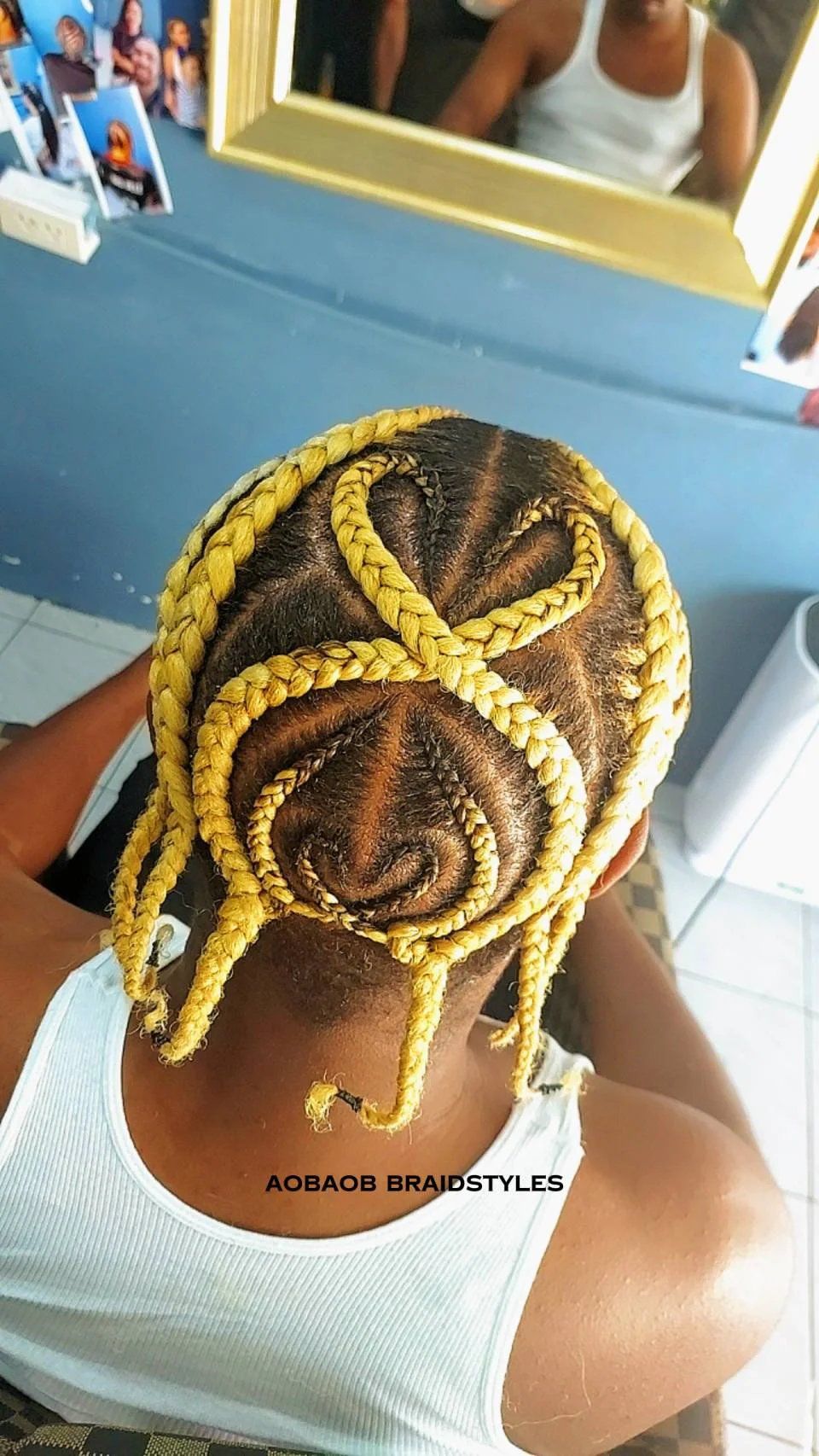 Creative cornrow design with yellow braid accents